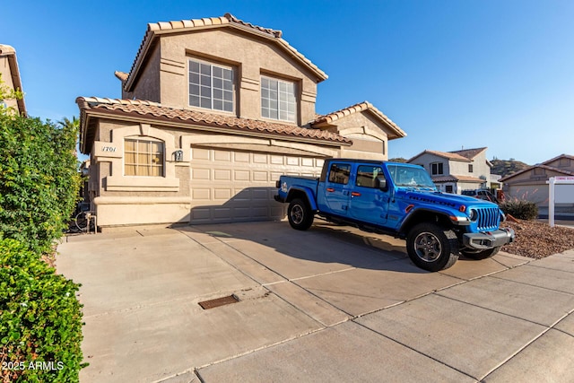view of front of house with a garage, driveway, stucco siding, and a tile roof