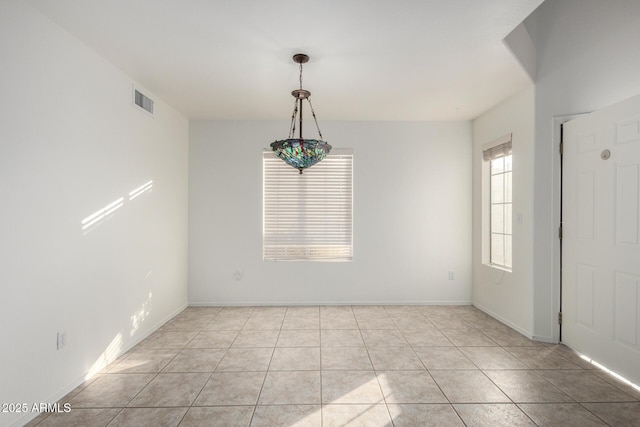 spare room with light tile patterned flooring, baseboards, and visible vents