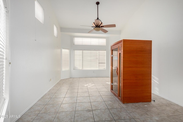 empty room with light tile patterned floors, ceiling fan, and baseboards