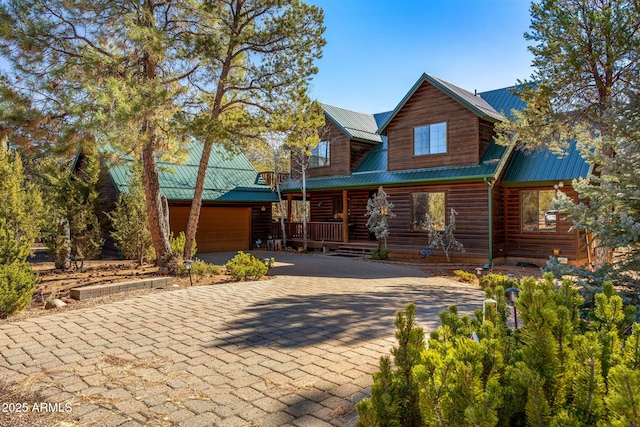 cabin featuring a garage and covered porch