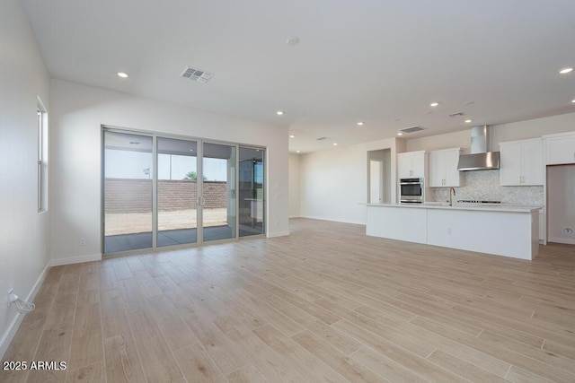 1254 E Penedes Dr, Gilbert, AZ 85298 - unfurnished living room with light wood-style floors, baseboards, a sink, and recessed lighting
