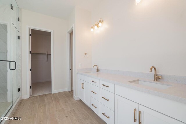 1254 E Penedes Dr, Gilbert, AZ 85298 - full bathroom with a marble finish shower, a spacious closet, wood finished floors, double vanity, and baseboards