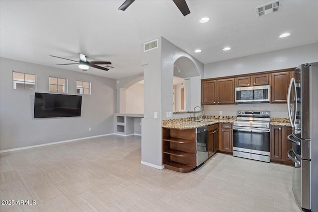 421 W Mountain Sage Dr, Phoenix, AZ 85045 - kitchen with appliances with stainless steel finishes, a ceiling fan, arched walkways, open floor plan, and recessed lighting