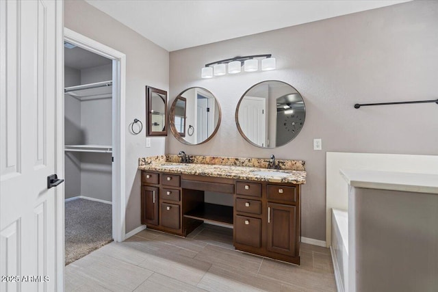421 W Mountain Sage Dr, Phoenix, AZ 85045 - bathroom featuring double vanity, a walk in closet, baseboards, and a tub to relax in