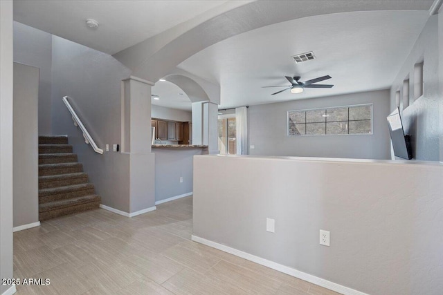 421 W Mountain Sage Dr, Phoenix, AZ 85045 - unfurnished living room featuring a ceiling fan, arched walkways, baseboards, and stairs