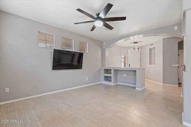 421 W Mountain Sage Dr, Phoenix, AZ 85045 - unfurnished living room with arched walkways, a ceiling fan, baseboards, and plenty of natural light