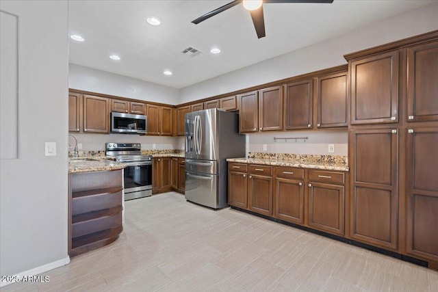 421 W Mountain Sage Dr, Phoenix, AZ 85045 - kitchen featuring stainless steel appliances, a ceiling fan, light stone counters, recessed lighting, and a sink