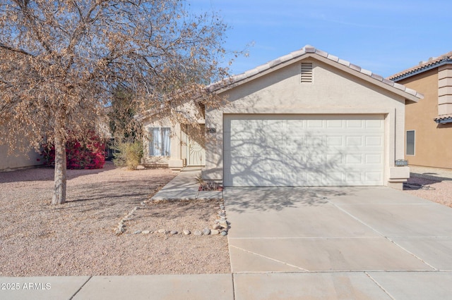 single story home with concrete driveway, a tiled roof, an attached garage, and stucco siding