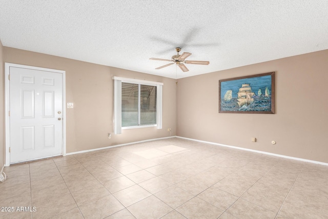 tiled empty room featuring a textured ceiling and ceiling fan