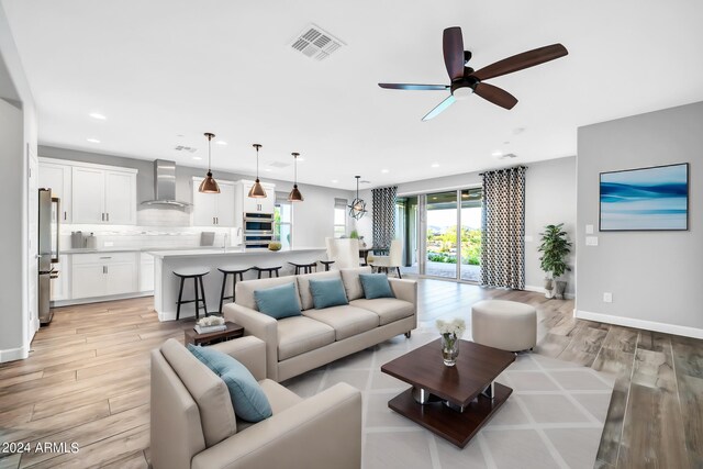 kitchen featuring stainless steel appliances, visible vents, light countertops, wall chimney range hood, and decorative backsplash