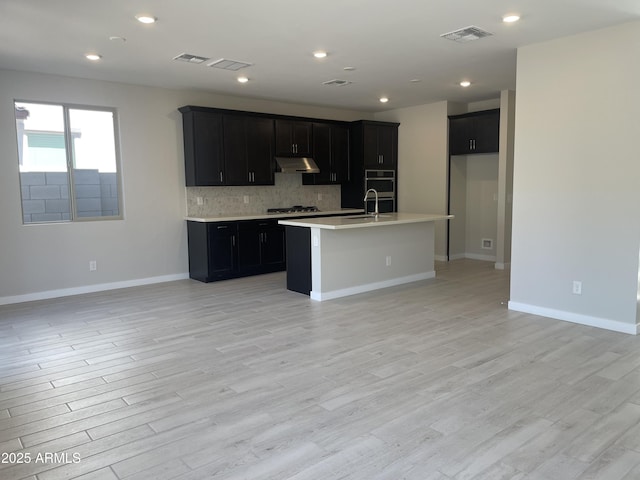 9366 E Sequence Ave, Mesa, AZ 85212 - kitchen with gas stovetop, tasteful backsplash, dark cabinetry, light wood-style flooring, and recessed lighting