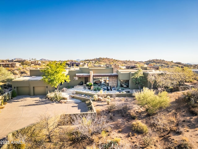 view of front of home featuring driveway, an attached garage, and stucco siding