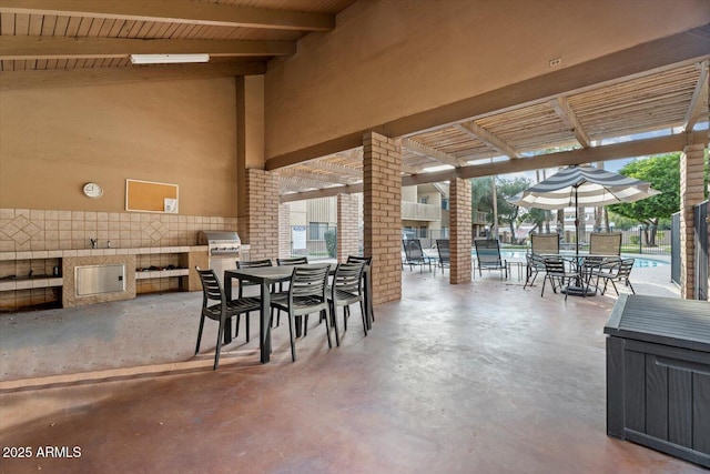 view of patio with area for grilling, a grill, and a pergola