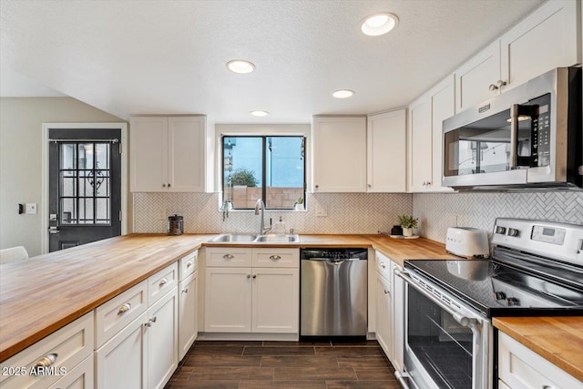 kitchen with stainless steel appliances, sink, wooden counters, and white cabinets