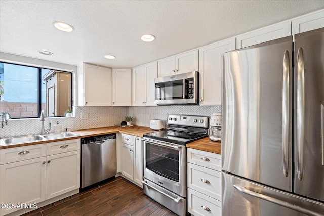 kitchen with white cabinetry, wood counters, appliances with stainless steel finishes, and sink