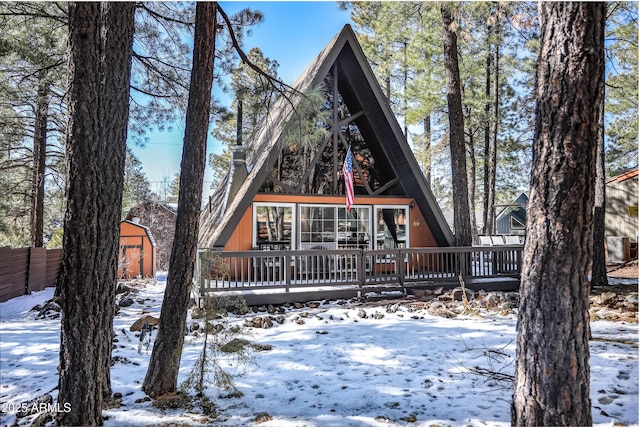 17660 S Stallion Dr, Munds Park, AZ 86017 - snow covered property with a wooden deck, an outdoor structure, and a storage shed