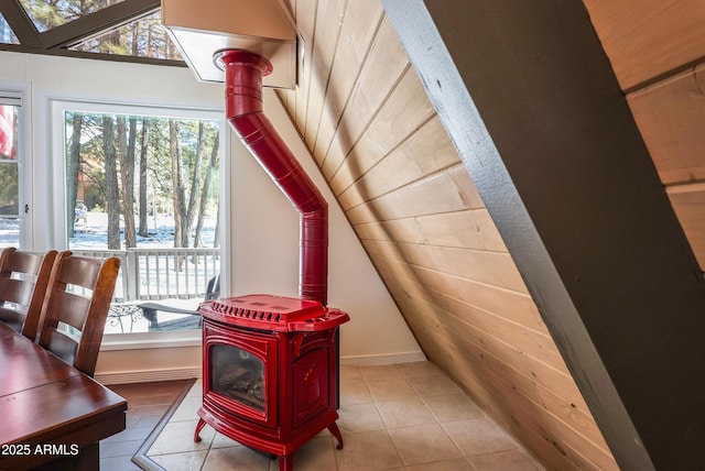 details featuring a wood stove, wood ceiling, and baseboards