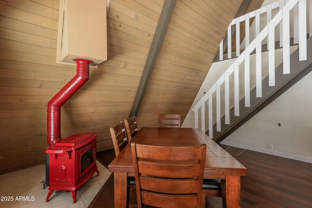 dining space featuring stairs, wooden walls, wood finished floors, and wood ceiling