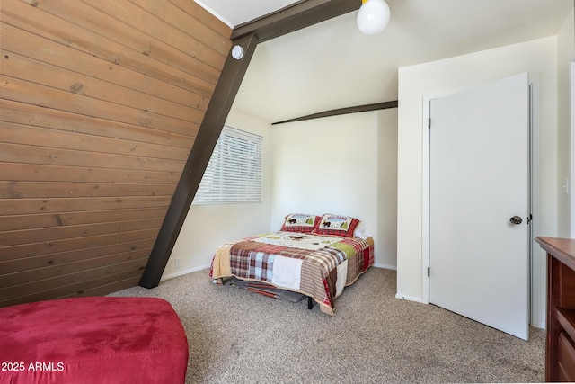 carpeted bedroom with wood walls, baseboards, and vaulted ceiling