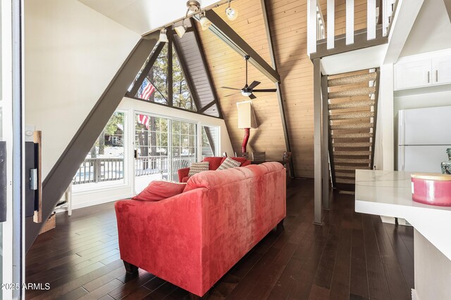 living room with dark wood finished floors, stairway, a ceiling fan, and beam ceiling