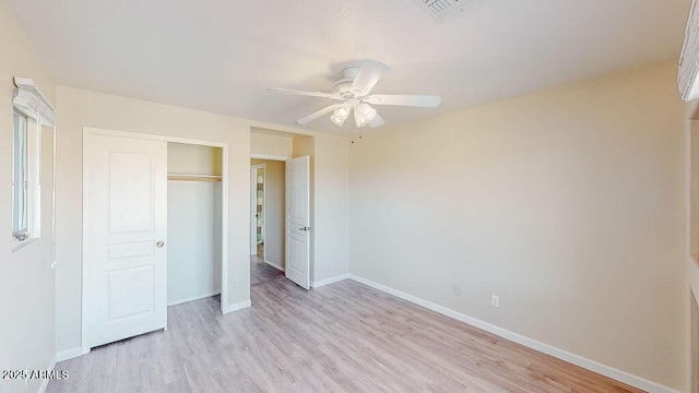 unfurnished bedroom with light hardwood / wood-style floors, a closet, and ceiling fan