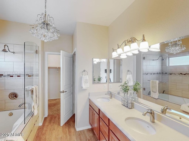 bathroom with wood-type flooring, shower / bath combination with glass door, and vanity