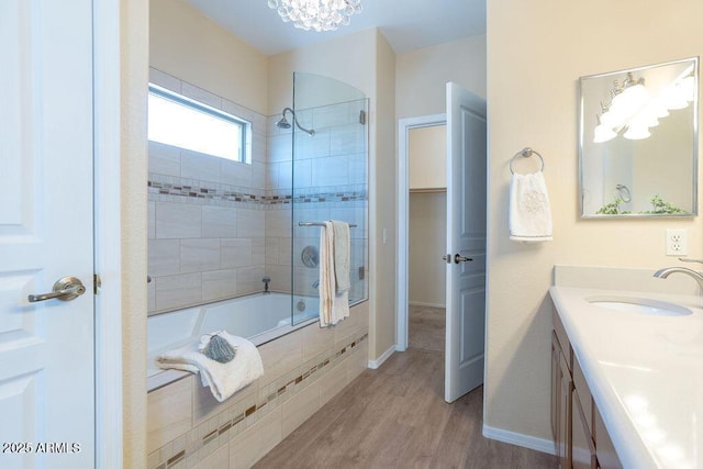 bathroom featuring hardwood / wood-style floors, tiled shower / bath, and vanity