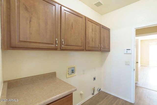 laundry room with hookup for a gas dryer, wood-type flooring, cabinets, electric dryer hookup, and washer hookup