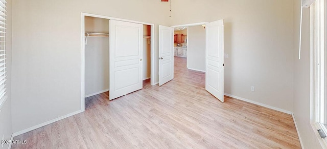 unfurnished bedroom featuring light wood-type flooring and a closet