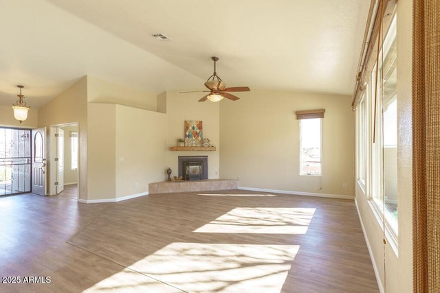 unfurnished living room with ceiling fan, hardwood / wood-style floors, a fireplace, and lofted ceiling