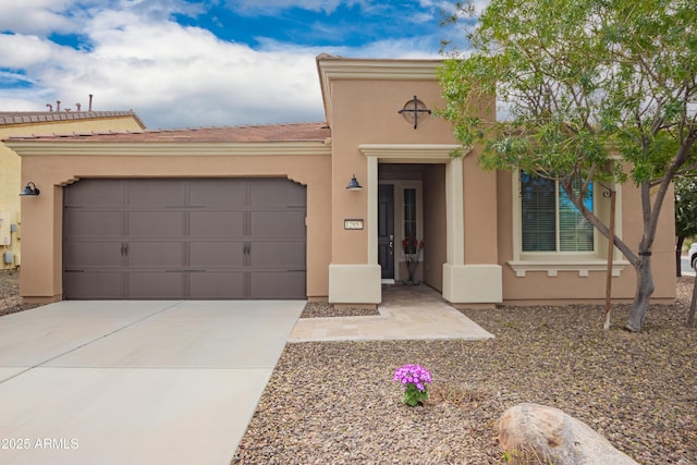 mediterranean / spanish house with a garage, driveway, and stucco siding