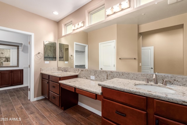 full bathroom with recessed lighting, vanity, baseboards, and wood finish floors