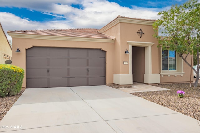 mediterranean / spanish-style home featuring concrete driveway, a tiled roof, an attached garage, and stucco siding