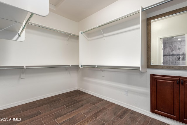 walk in closet with wood finish floors