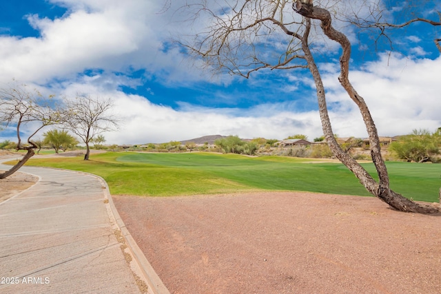 view of home's community with view of golf course and a lawn