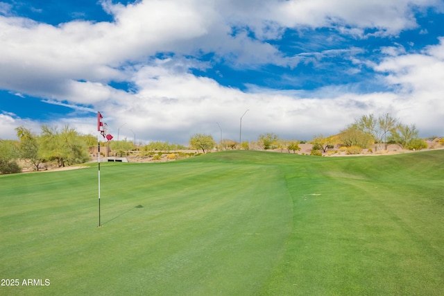 view of home's community featuring view of golf course and a lawn