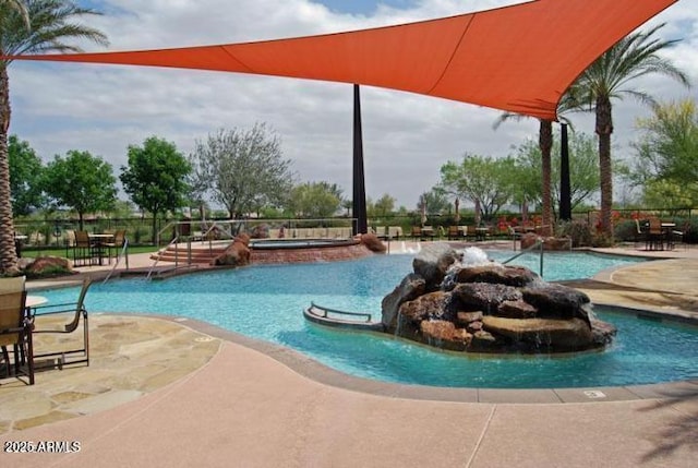 community pool with a patio and fence