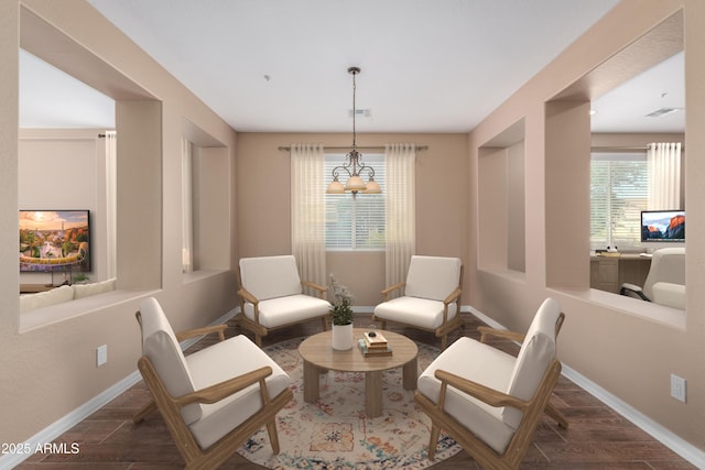 living area with a notable chandelier, baseboards, and wood finished floors