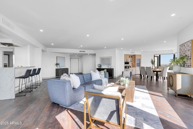 living area with dark wood-style floors, recessed lighting, and visible vents