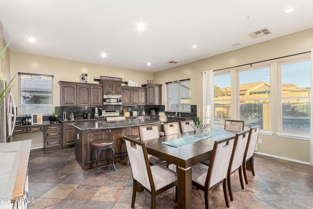 dining space featuring recessed lighting, stone finish floor, baseboards, and visible vents