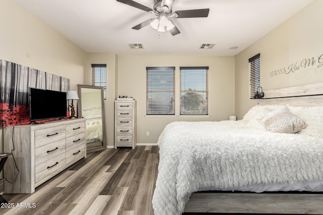 bedroom with baseboards, dark wood-style floors, visible vents, and ceiling fan