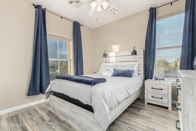 bedroom featuring light wood finished floors, multiple windows, and visible vents