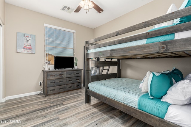 bedroom featuring baseboards, ceiling fan, visible vents, and wood finished floors