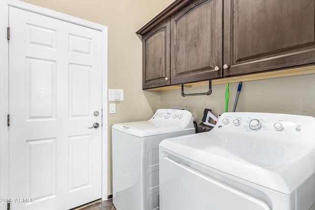 washroom featuring cabinet space and washer and clothes dryer
