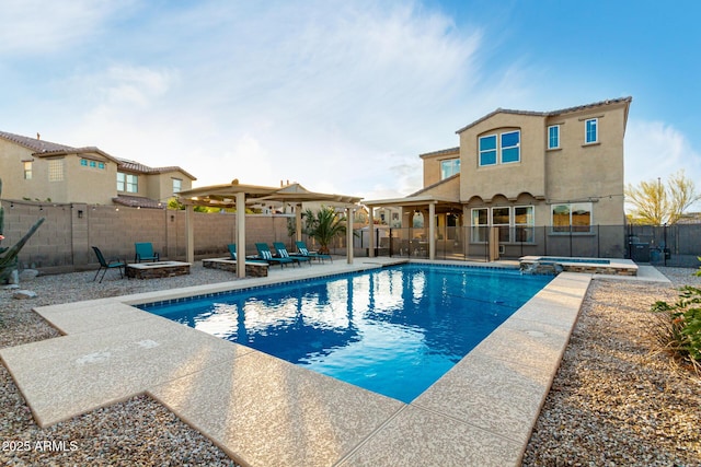 view of swimming pool with a fenced backyard, an outdoor fire pit, a pool with connected hot tub, and a patio area
