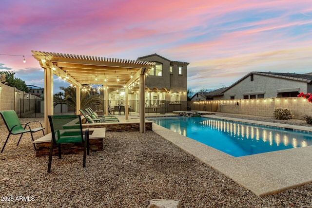pool at dusk featuring a pergola, a pool with connected hot tub, a fenced backyard, and a patio
