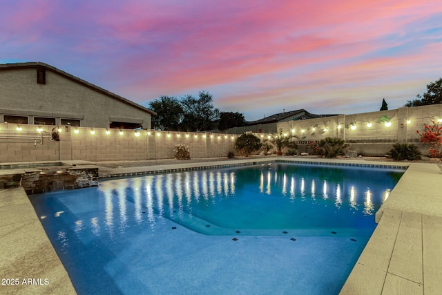 view of pool with a fenced backyard and a pool with connected hot tub