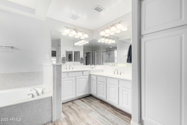 bathroom with vanity, wood-type flooring, and shower with separate bathtub