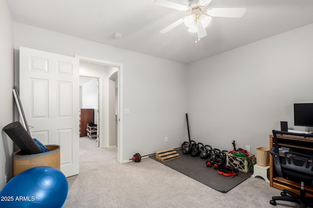 exercise room with light colored carpet and ceiling fan