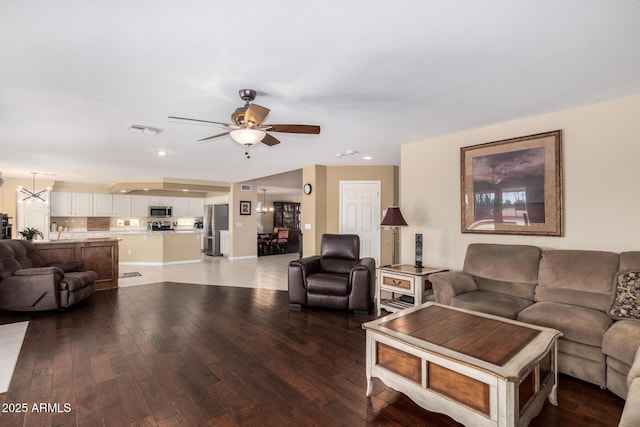 living room with hardwood / wood-style floors and ceiling fan with notable chandelier